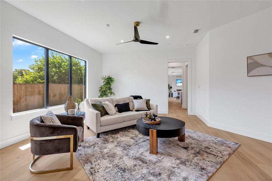 Living room with a ceiling fan, recessed lighting, and light wood-style floors Living room with a ceiling fan, recessed lighting, and light wood-style floors
