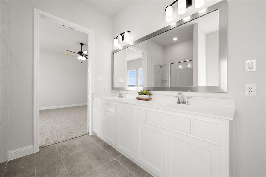 Bathroom featuring ceiling fan, a shower, vanity, and tile patterned flooring