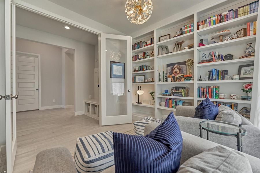 Custom-built library wall, sphere chandelier, and French doors for a wonderful workspace.