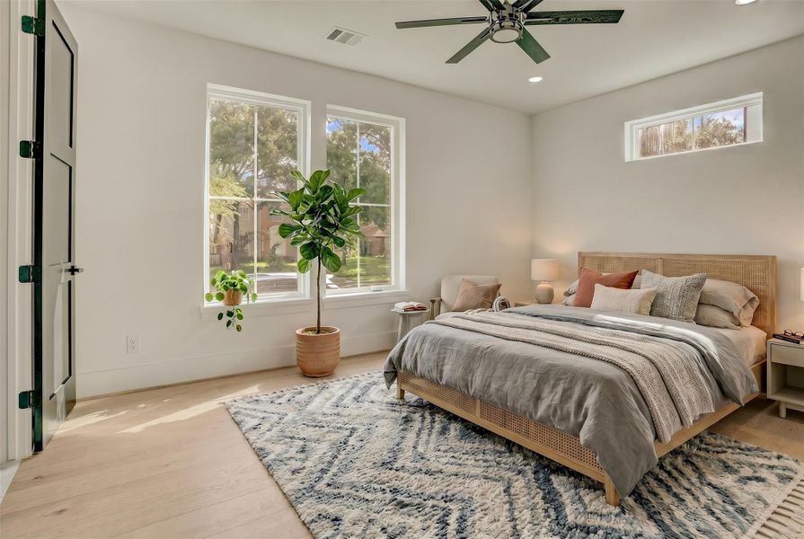 On the first floor, a large bedroom with ensuite bathroom access is available with ground level views. Virtually staged photo. On the first floor, a large bedroom with ensuite bathroom access is available with ground level views. Virtually staged photo.