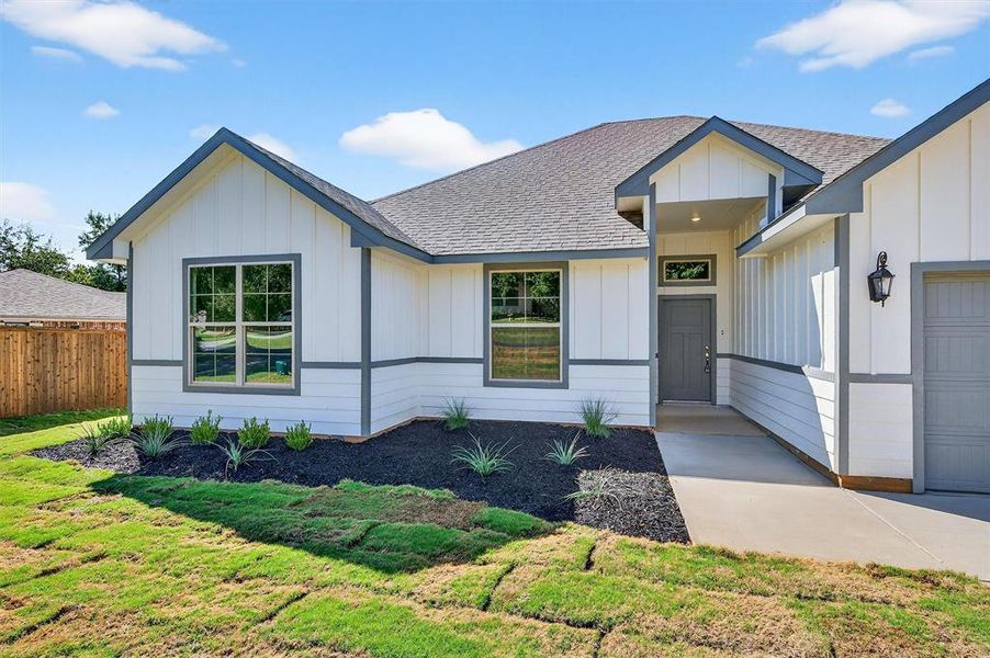 Modern farmhouse with a shingled roof, board and batten siding, and a garage