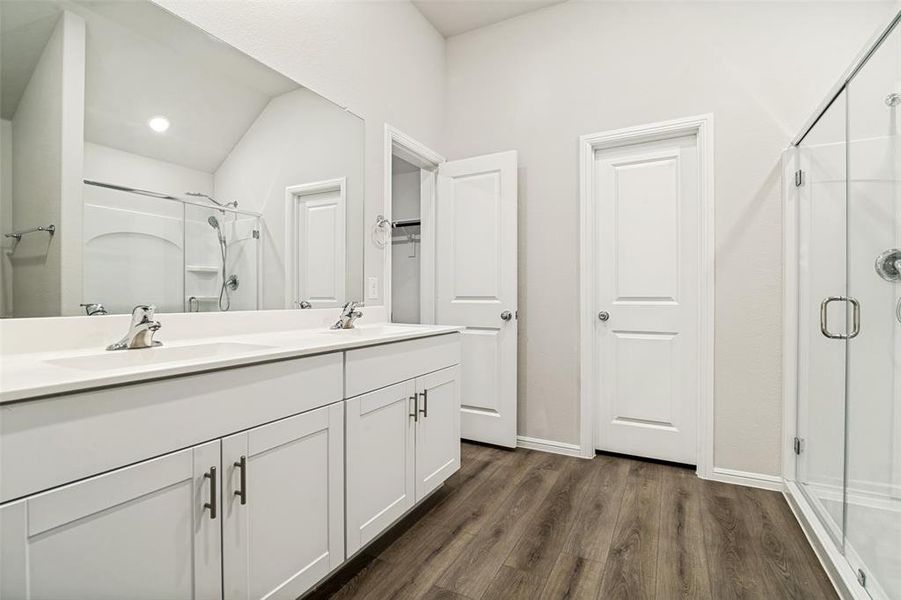 Bathroom featuring a dual vanity with white cabinetry, integrated sinks, and chrome faucets Bathroom featuring a dual vanity with white cabinetry, integrated sinks, and chrome faucets