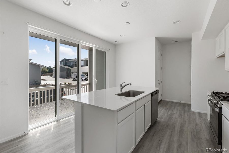 Spacious kitchen features island, breakfast bar and walks out to the covered patio