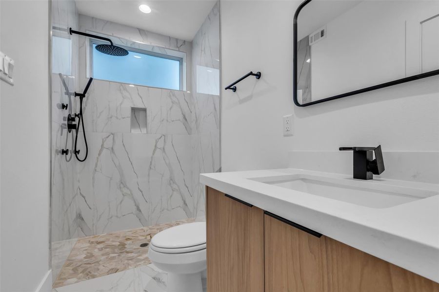 The en-suite bathroom features modern finishes, a sleek shower area, and a single-sink vanity designed for both comfort and functionality. The en-suite bathroom features modern finishes, a sleek shower area, and a single-sink vanity designed for both comfort and functionality.