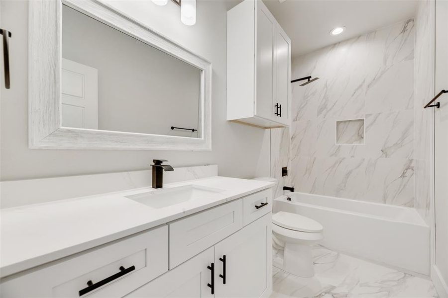 Full bathroom with vanity, light marble finish flooring, and tub / shower combination