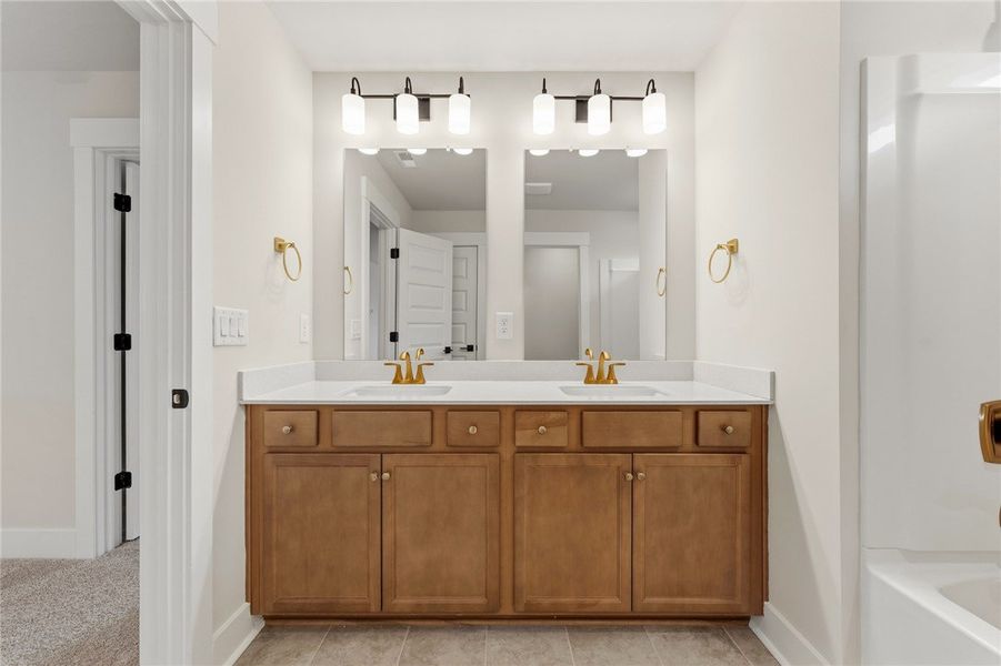 This primary bathroom offers dual vanities with am