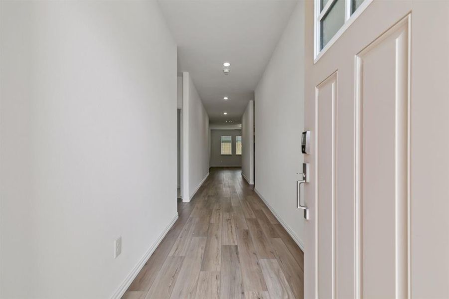 Corridor with light hardwood / wood-style flooring