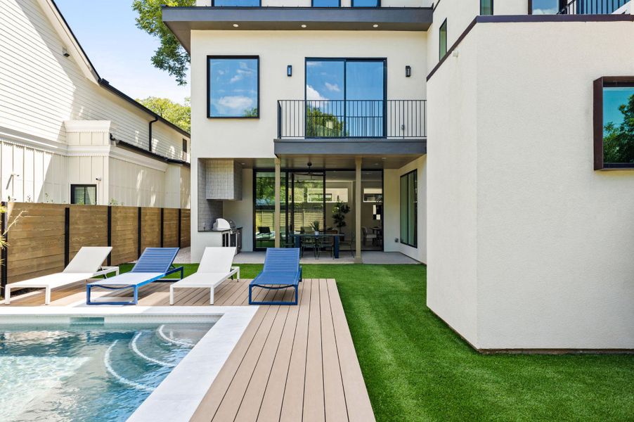 An inviting backyard oasis showcases a pristine swimming pool alongside a modern stucco exterior. An inviting backyard oasis showcases a pristine swimming pool alongside a modern stucco exterior.