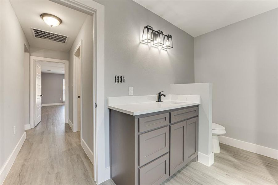 Bathroom with vanity, toilet, and hardwood / wood-style floors