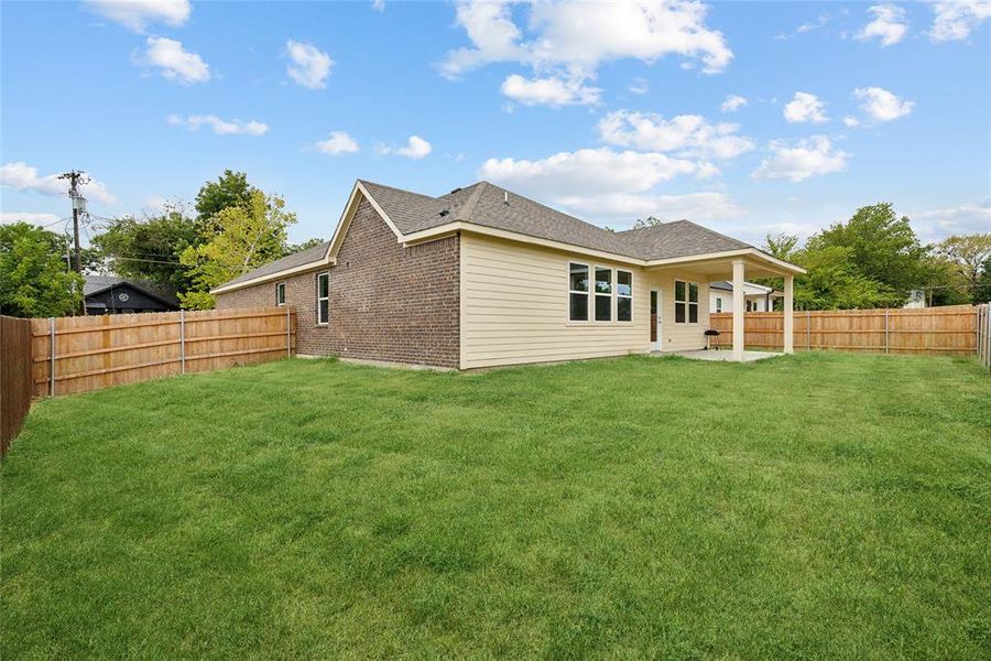 Back of property with a patio area and a lawn