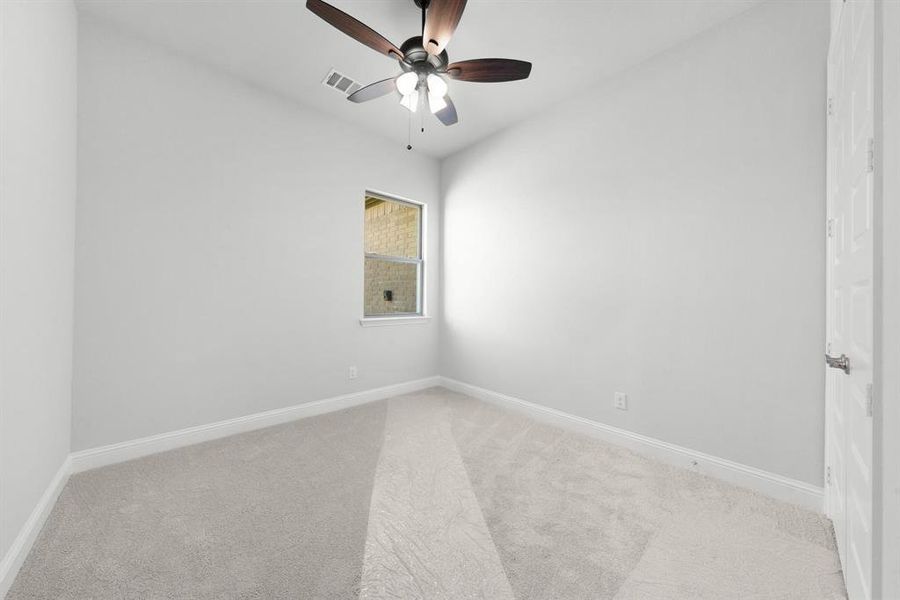 Secondary bedroom featuring baseboards and ceiling fan.