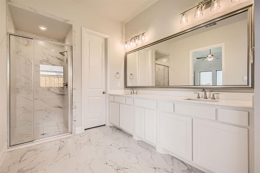 Bathroom with an enclosed shower, vanity, and ceiling fan