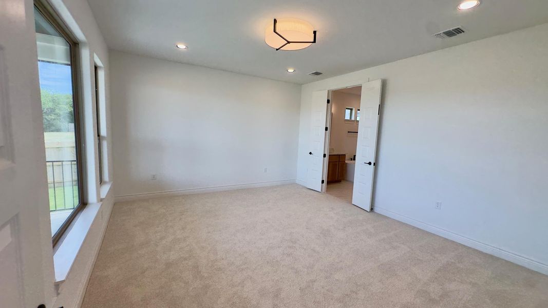 Spare room featuring light colored carpet and recessed lighting