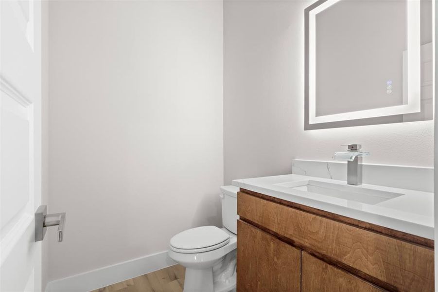 Bathroom with toilet, vanity, and hardwood / wood-style flooring