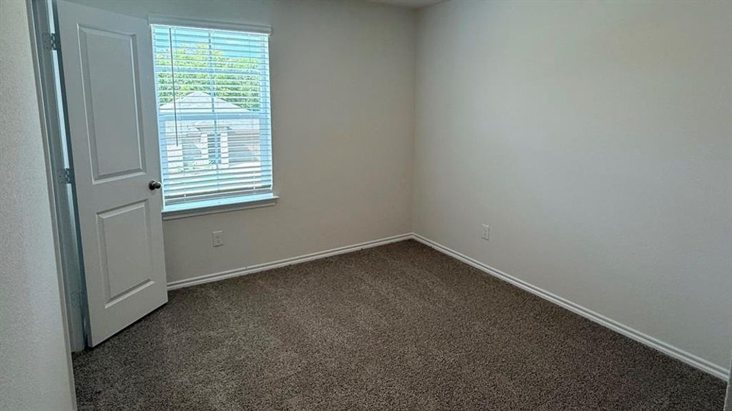 Unfurnished room featuring dark colored carpet and baseboards Unfurnished room featuring dark colored carpet and baseboards