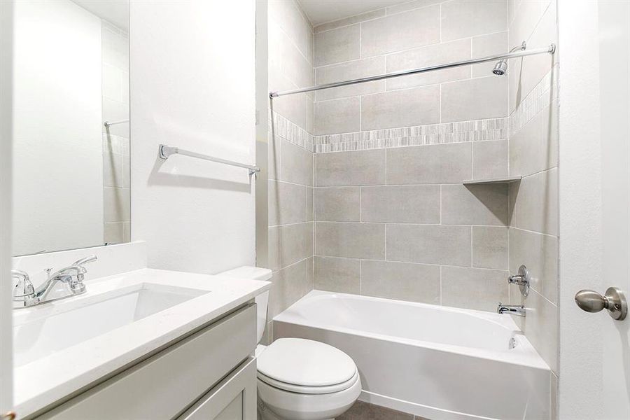 Secondary bath with quartz counter tops and beautiful tile selections.