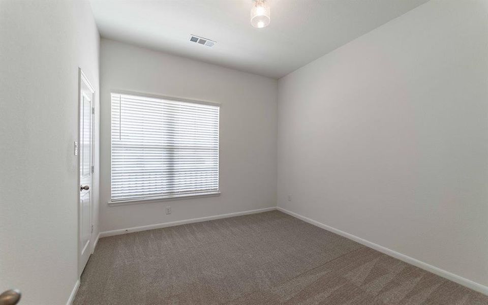 Room with neutral carpeting and white walls