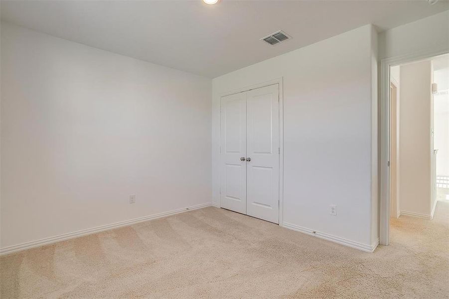 Unfurnished bedroom featuring light colored carpet and a closet