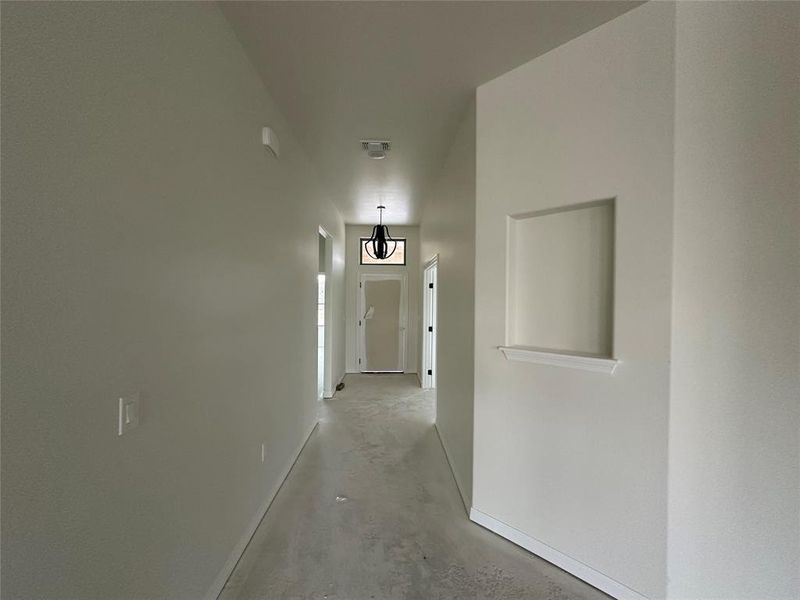 Hall featuring concrete flooring and baseboards