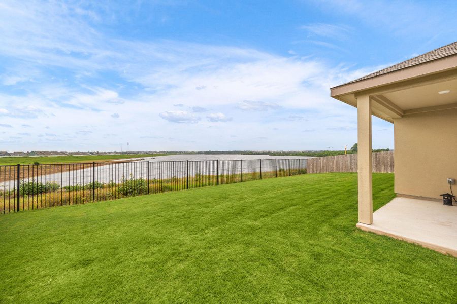 Enjoy tranquil water views from the covered patio and spacious, verdant yard.