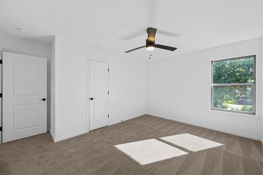 Unfurnished bedroom featuring ceiling fan and carpet floors