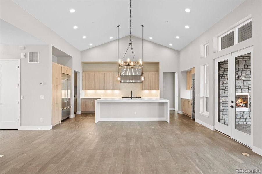 Chef's kitchen with quartz countertop, waterfall edge center island, counter seating for 6+, upgraded cabinetry, and a Thermador 6-burner plus griddle gas range.