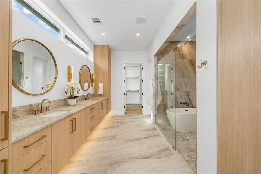 Full bath featuring a soaking tub, double vanity, a shower stall, a walk in closet, and recessed lighting