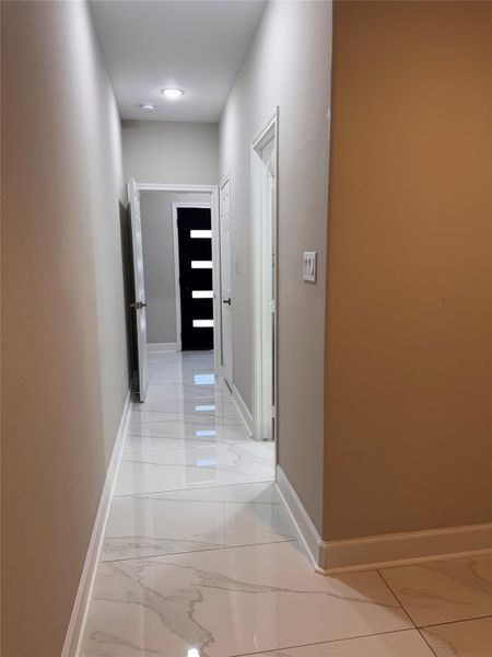Sleek, modern hallway with glossy marble floors and contemporary doors, leading to a bright, inviting space. Sleek, modern hallway with glossy marble floors and contemporary doors, leading to a bright, inviting space.