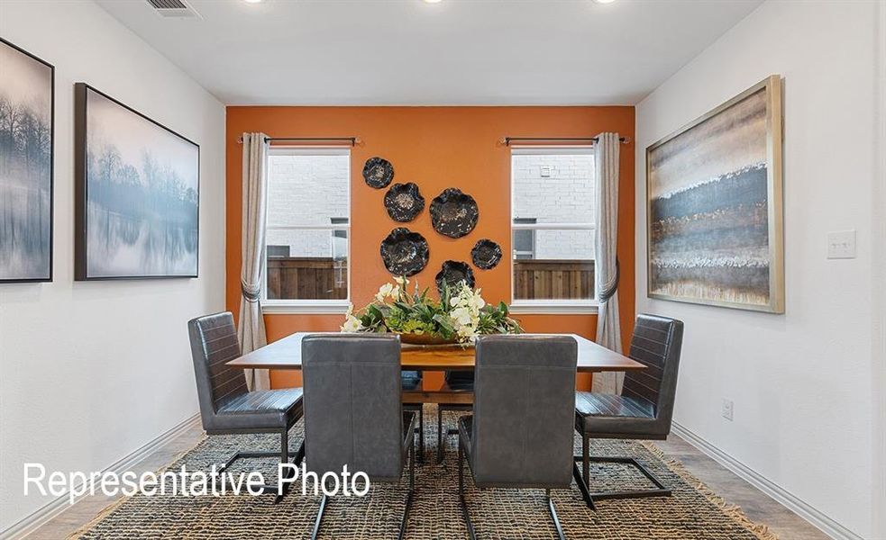 Dining area featuring an accent wall, two windows, recessed lighting, and wood-finish flooring