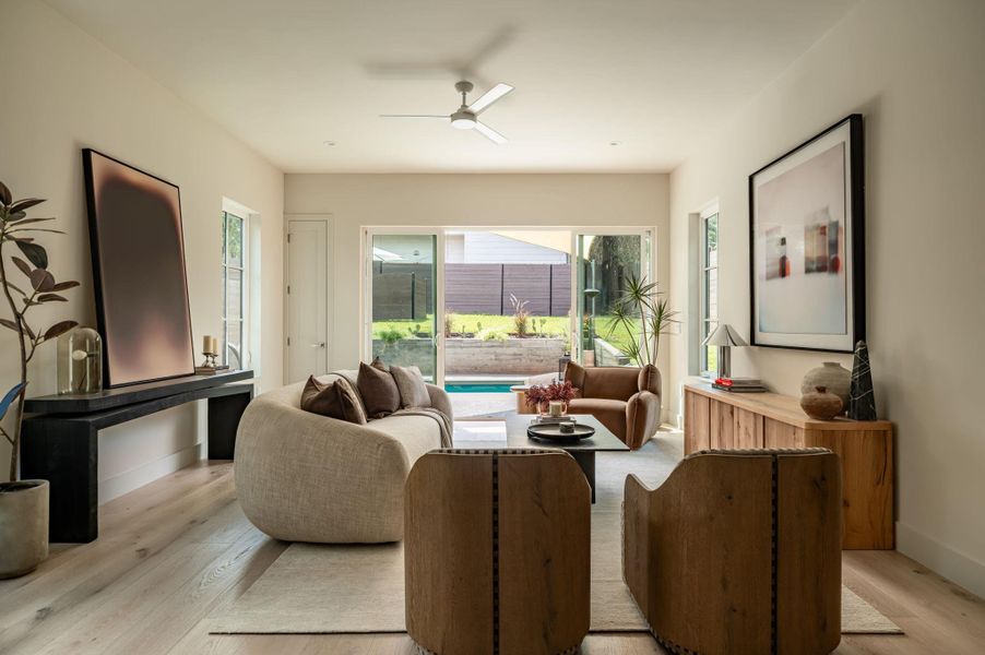Wide sliding glass doors connect this airy living space directly to the backyard pool. Wide sliding glass doors connect this airy living space directly to the backyard pool.