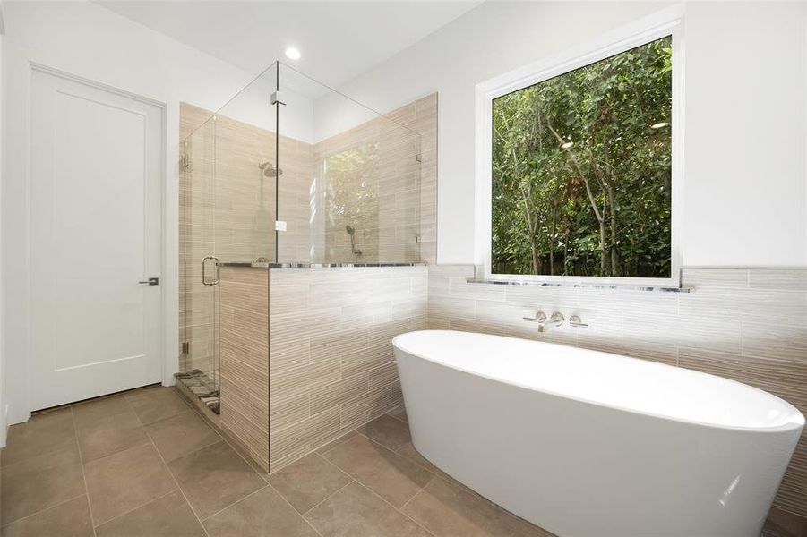 Bathroom featuring a freestanding tub, a shower stall, tile walls, and tile patterned floors Bathroom featuring a freestanding tub, a shower stall, tile walls, and tile patterned floors