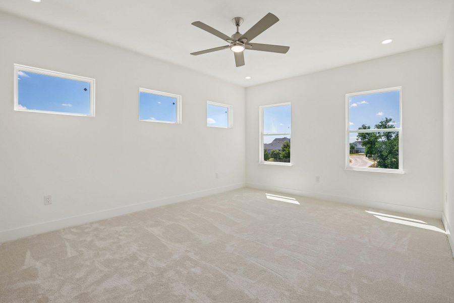 Plentiful windows frame blue skies over this comfortable, carpeted living space.