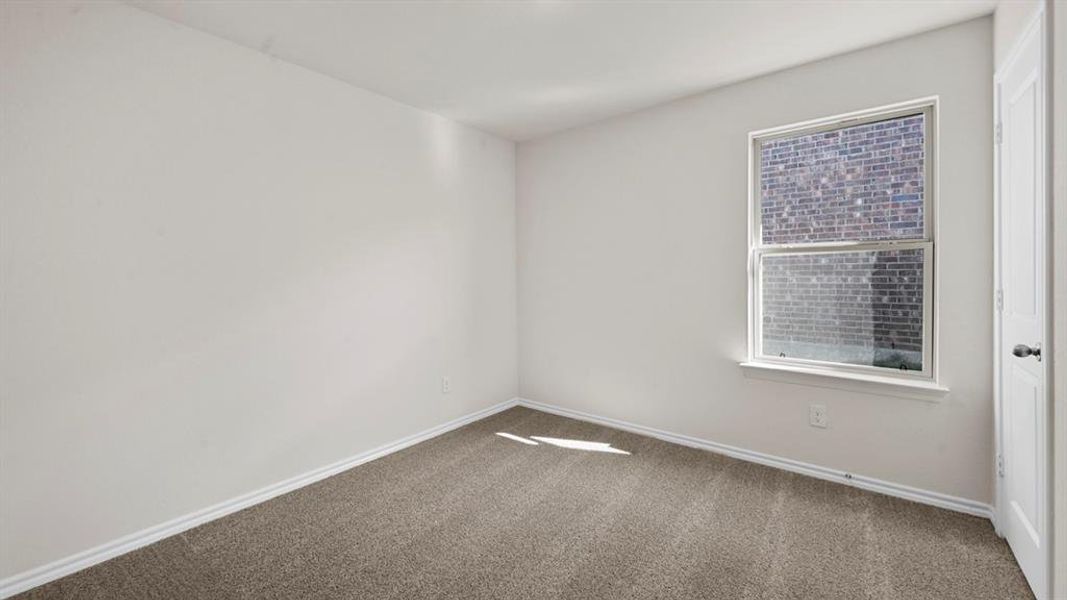 Empty room with dark carpet and baseboards
