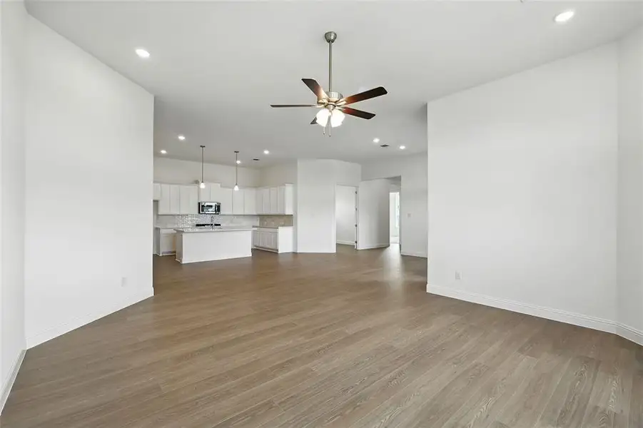 Unfurnished living room with light wood-type flooring, recessed lighting, and ceiling fan