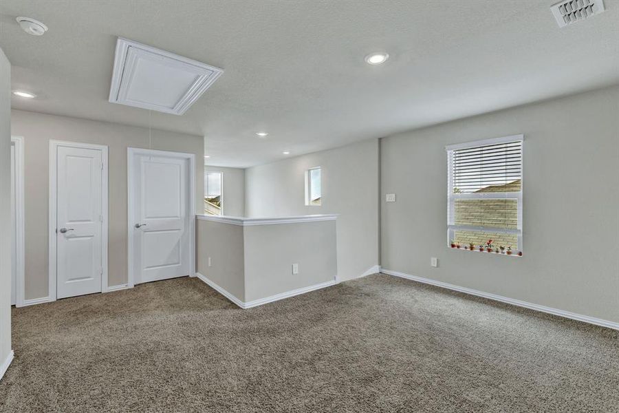 This versatile space features carpeting, recessed lighting, and a window with blinds, offering natural light