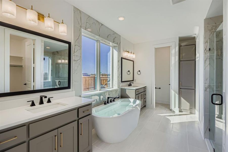 Bathroom with a soaking tub, two vanities, a marble finish shower, light tile patterned floors, and recessed lighting