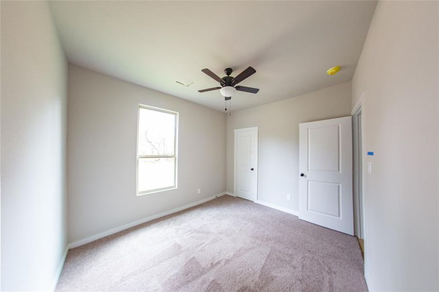 Unfurnished bedroom featuring carpet floors and ceiling fan