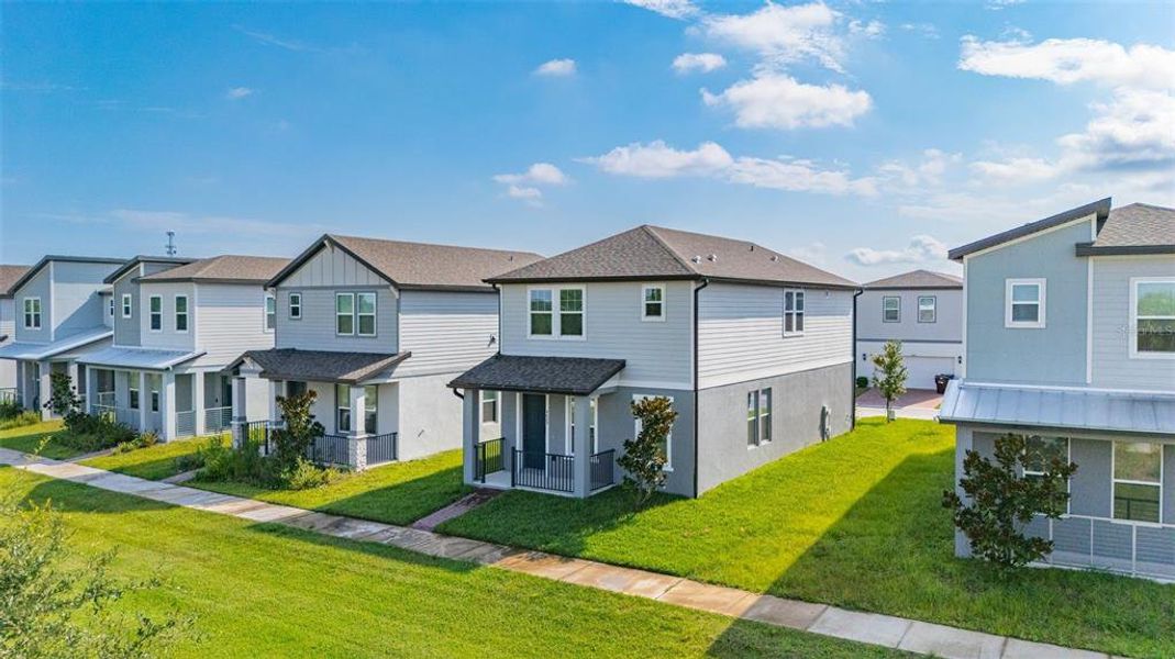 Front exterior of a new home in The Meadow at Crossprairie Bungalows, St. Cloud, FL, highlighting curb appeal (Image 26). Front exterior of a new home in The Meadow at Crossprairie Bungalows, St. Cloud, FL, highlighting curb appeal (Image 26).