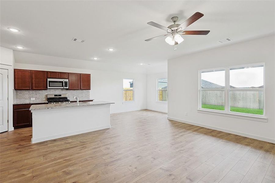 Kitchen with a wealth of natural light, light wood-type flooring, and appliances with stainless steel finishes