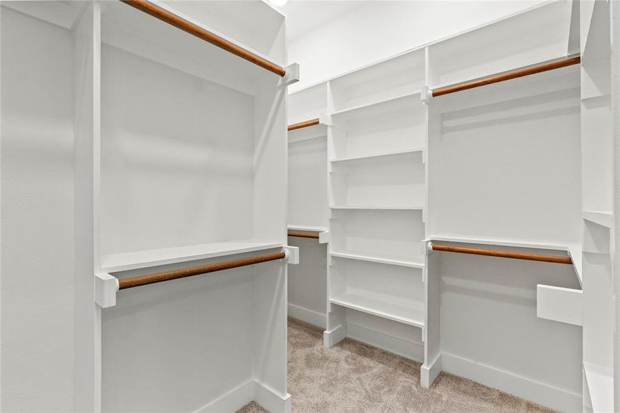 Spacious closet with light colored carpet Spacious closet with light colored carpet