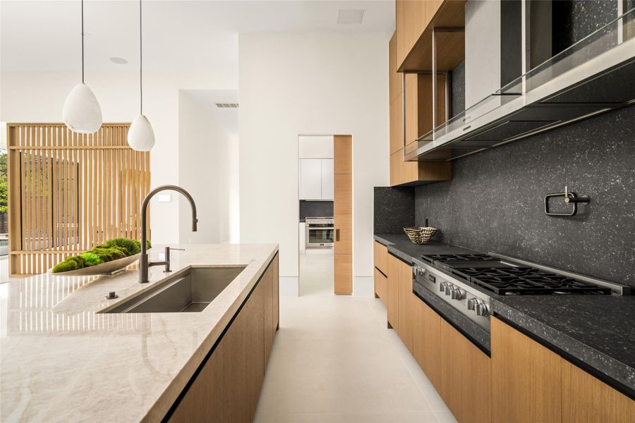 Thoughtfully designed kitchen with premium appliances and a seamless transition to the scullery beyond.