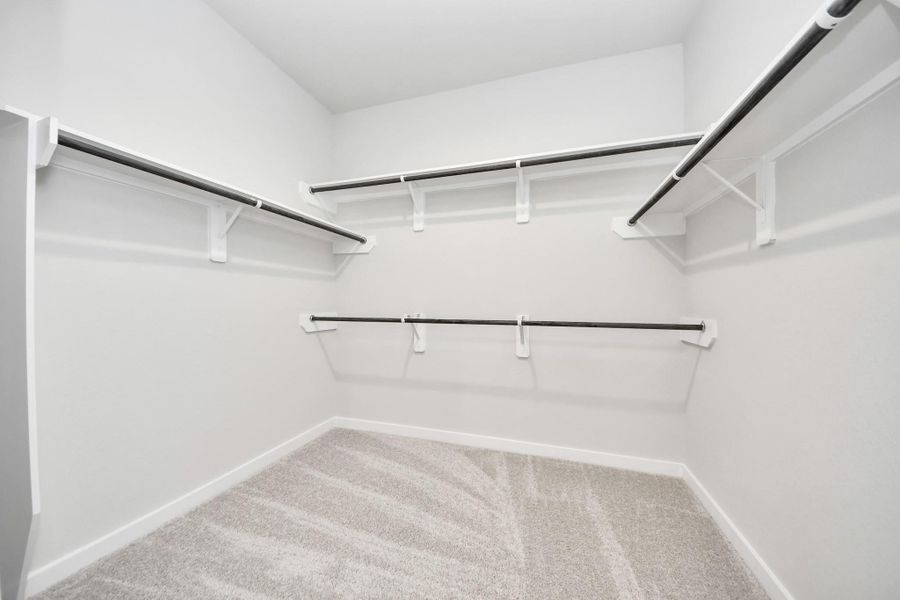 Walk-in closet that epitomizes luxury and practicality. This generously sized space features built-in shelving, offering abundant room for impeccable organization. High ceilings and recessed lighting create a bright and welcoming ambiance. Sample photo of completed home with similar floor plan. Actual colors and selections may vary. Walk-in closet that epitomizes luxury and practicality. This generously sized space features built-in shelving, offering abundant room for impeccable organization. High ceilings and recessed lighting create a bright and welcoming ambiance. Sample photo of completed home with similar floor plan. Actual colors and selections may vary.