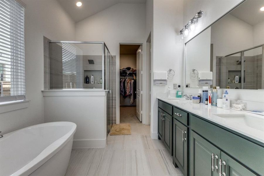 Full bathroom featuring a shower stall, double vanity, a spacious closet, recessed lighting, and a soaking tub
