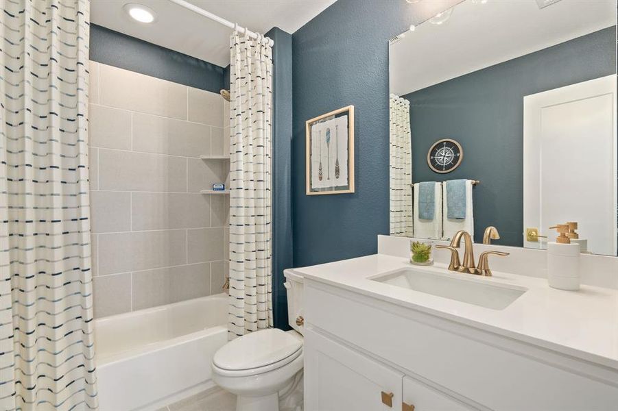 Full bathroom featuring shower / bath combo with shower curtain, vanity, and a textured wall Full bathroom featuring shower / bath combo with shower curtain, vanity, and a textured wall