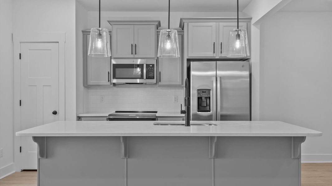 Exclusive DRB Homes kitchen with a 9-foot island, elevated finishes, and pendant lighting in a prime location