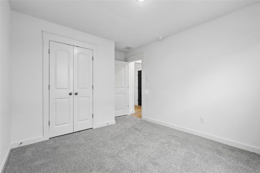 Unfurnished bedroom featuring carpet flooring and a closet