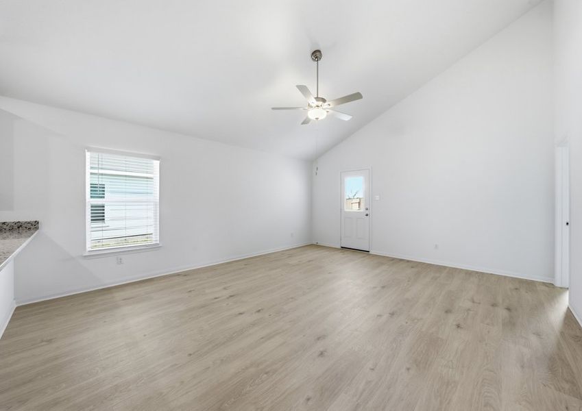 Family room featuring a ceiling fan, a window with natural light, and wood-look vinyl flooring. Family room featuring a ceiling fan, a window with natural light, and wood-look vinyl flooring.