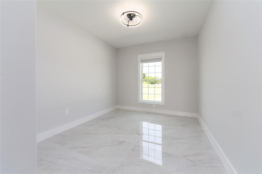 3rd bedroom with light marble finish floors and baseboards