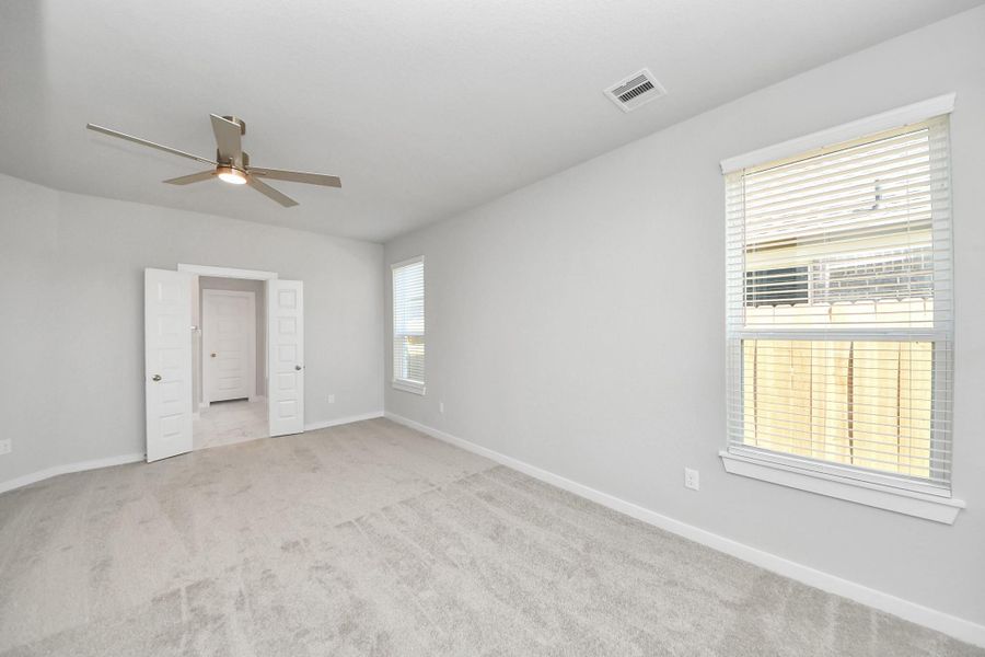 Escape to tranquility in this spacious primary room, adorned with plush carpeting and bathed in the soothing hues of warm paint colors, creating a cozy retreat for relaxation. Sample photo of completed home with similar floor plan. Actual colors and selections may vary. Escape to tranquility in this spacious primary room, adorned with plush carpeting and bathed in the soothing hues of warm paint colors, creating a cozy retreat for relaxation. Sample photo of completed home with similar floor plan. Actual colors and selections may vary.