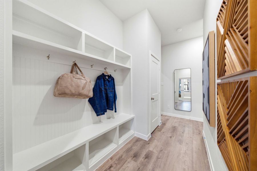 A white room with a wood floor and a wood staircase. A white room with a wood floor and a wood staircase.